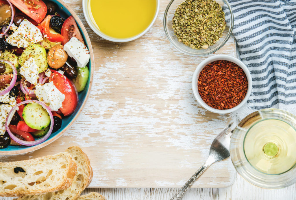 Greek salad with olive oil, bread, herbs and white wine